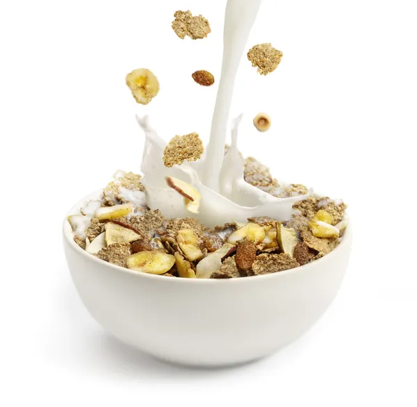 Verter leche en un tazón con cereales para el desayuno — Foto de Stock
