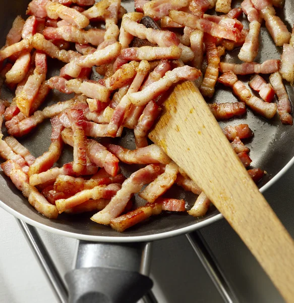 Strisce di pancetta che friggono in una padella — Foto Stock