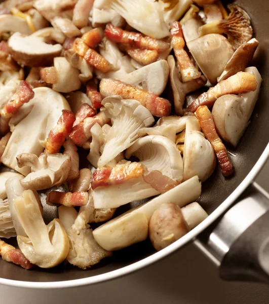 Cuisson des champignons et du bacon — Photo