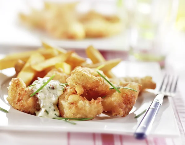 Peixe e batatas fritas servidos em um prato — Fotografia de Stock