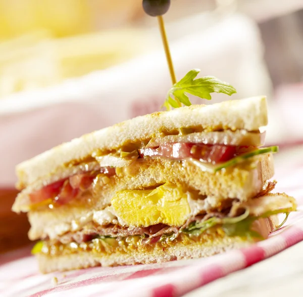 Sandwich with three layers, filled with bacon eggs and lettuce — Stock Photo, Image