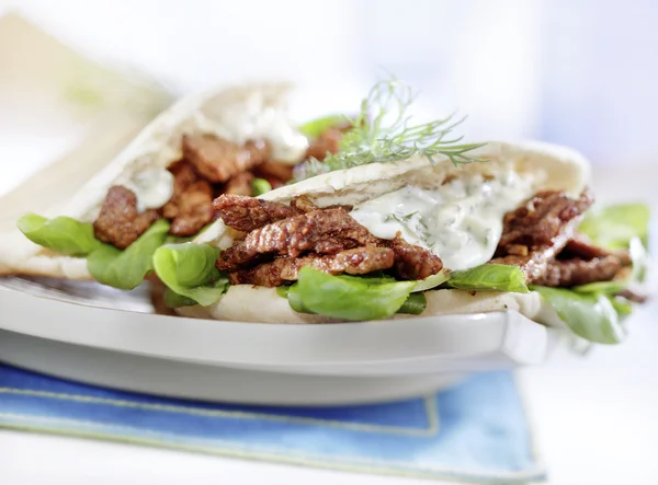 Pita with gyros served on a plate with lettuce — Stock Photo, Image