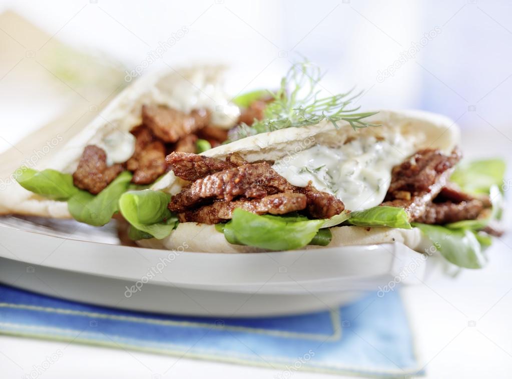 Pita with gyros served on a plate with lettuce