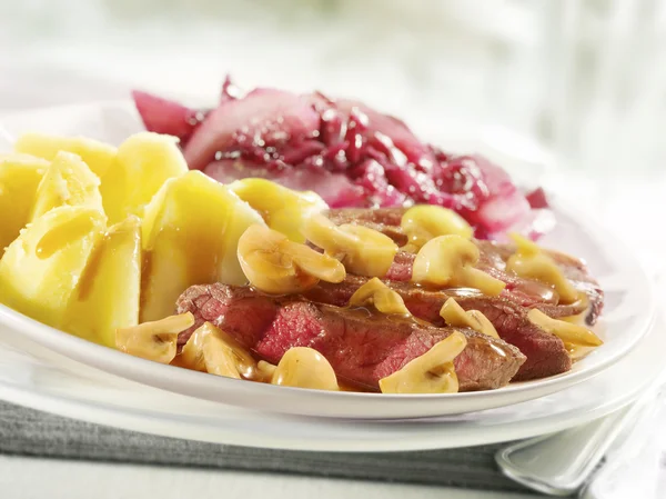 Stek z ziemniakami i sosem na talerzu — Zdjęcie stockowe