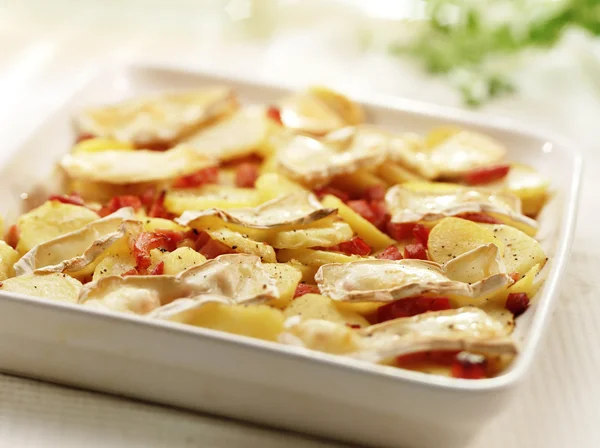 Deliciosas patatas asadas caseras con queso y tocino en un plato de horno —  Fotos de Stock