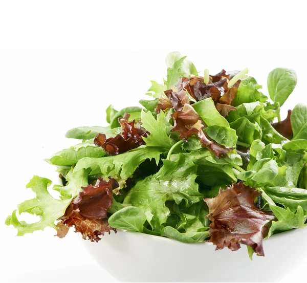 Salada mista fresca em uma tigela de perto em um fundo branco — Fotografia de Stock