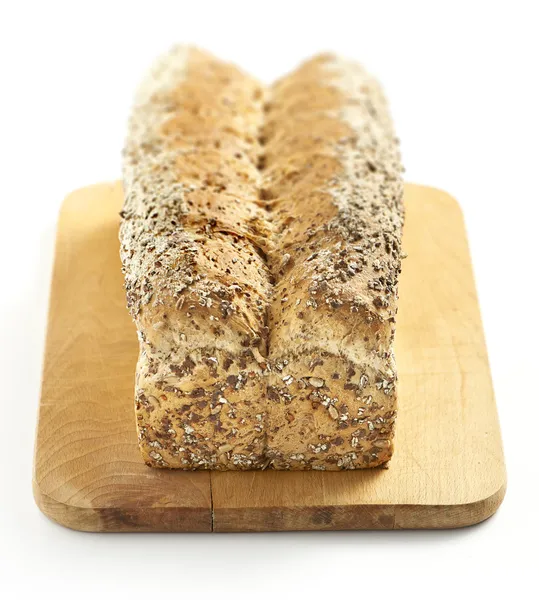 Многозерновой хлеб на доске для рубки — стоковое фото
