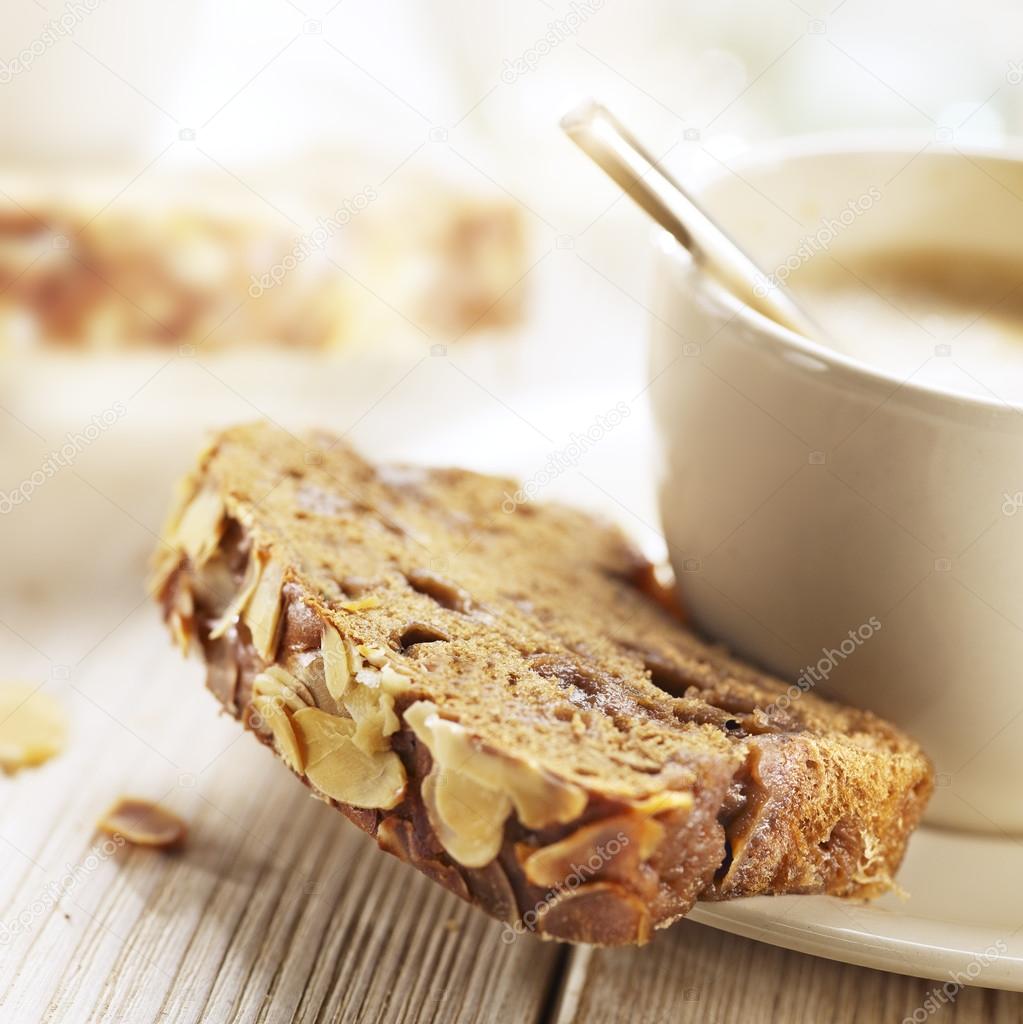 cup of coffee served with suger bread and almonds