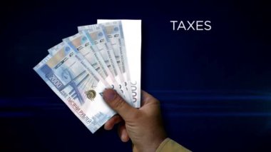 Rus Rublesi kağıt para tutuyor. Rub banknotlarının hayranı. Rusya 'da gelir kaybı, yaşam maliyeti, vergi, kredi ve para azalması metaforu.