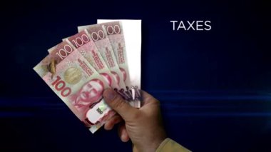 Yeni Zelanda Doları kağıt para tutuyor. NZD banknotlarının hayranı. Gelir kaybı, yaşam, vergi, kredi ve para kaybı metaforu.