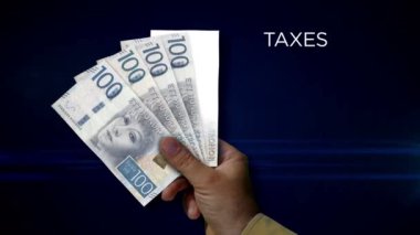 İsveç Kronu kâğıdı tutuyor. NZD banknotlarının hayranı. Gelir kaybı, yaşam, vergi, kredi ve para kaybı metaforu.