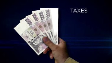 Çek koruna kağıdı tutuyor. NZD banknotlarının hayranı. Gelir kaybı, yaşam, vergi, kredi ve para kaybı metaforu.