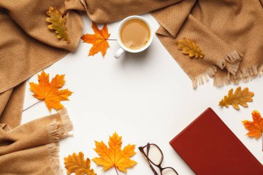 Bej kaşmir atkı, sonbahar akçaağaç ve meşe yapraklı kahve fincanı gri arka planda gözlük kitabı. Düz konum, üst görünüm, kopyalama alanı