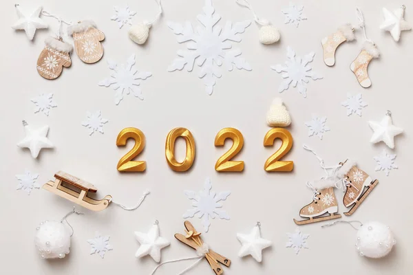 New Year lettering 2022 numbers in gold color on gray background. Wooden decorations with winter sports. Flat lay top view