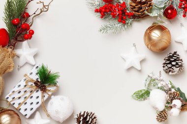 Yeni yıl kartı. Noel hediyesi olarak, köknar dalları gri arka planda çam kozalakları topları. Düz görünüm kopyalama alanı