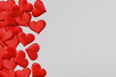 Sevgililer Günü. Gri renkli arka planda bir sürü kırmızı kalp var. Üst görünüm düz kopya alanı.