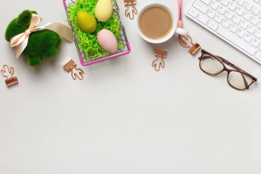 Masaüstünün üst görüntüsü. Paskalya süslü bir fincan kahve bardağı klavyesi. Düz metin kopyalama alanı
