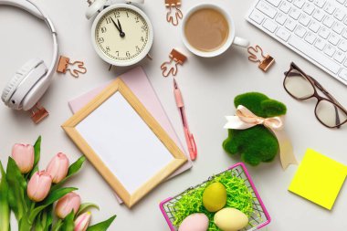Masaüstü. Paskalya süslemeleri ile birlikte masanın üzerinde klavye kahve fincanı çalar saati var. Fotokopi alanı olan fotoğraf çerçevesi