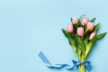 Paskalya ve bahar konsepti. Mavi arka planda bir buket pembe lale. Düz yatay kopyalama alanı üst görünümü.