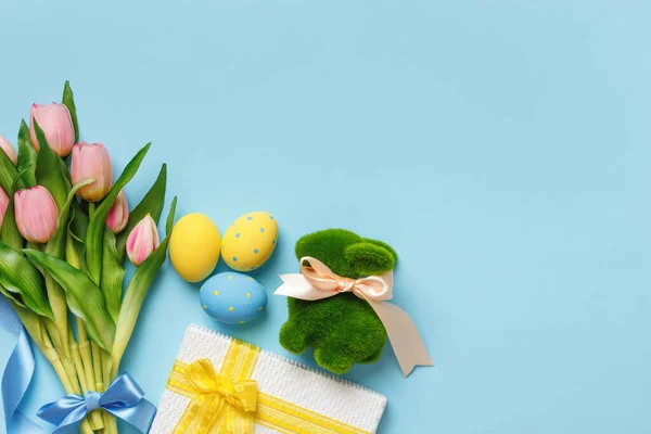 チューリップ春の花は青い背景に卵の贈り物ウサギをイースター トップ表示フラットレイコピースペース — ストック写真
