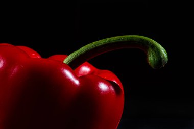 Red pepper, capsicum, on black background.