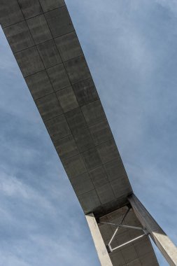 Underside of a concrete walking bridge between buildings..
