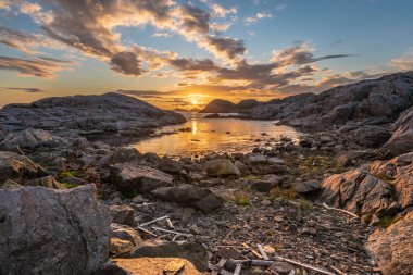 Küçük bir körfezin üzerinde altın gün batımı.