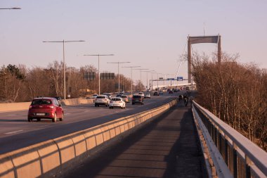 Göteborg, İsveç - 23 Mart 2022: İşten eve giden bisikletçiler otobana paralel gidiyorlar.