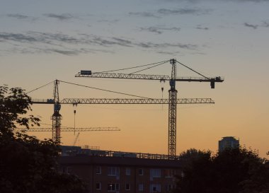 Gün batımında iki kule vinci.