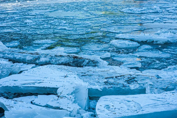 Blue ice flakes in a river.