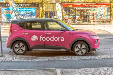 İçinde Foodora logosu olan Pembe Kia Soul elektrikli araba...