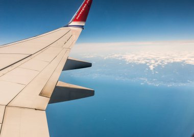 Norveç 'in güneşli güney kıyısındaki uçak kanadına bakıyorum. Norveç LN-NHD OSL 'den LIS' e gidiyor..