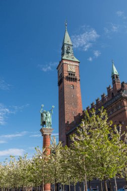 Kopenhag, Danimarka - 12 Mayıs 2017: Radhuspladsen 'deki Horn Blowers heykeli ve saat kulesi.