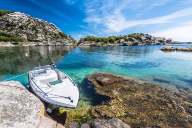 Spangereid, Norveç - 21 Haziran 2017: Resimli bir körfezdeki güneşli uçurumlara demirlemiş sürat teknesi.