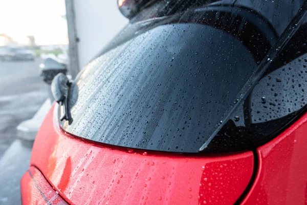 Water drops on the back of a newly washed red car.