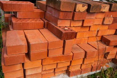 Staples of red bricks on a pallet.