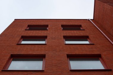Looking up a red brick apartment building.