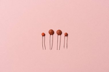 Assortment of ceramic capacitors on pink background.