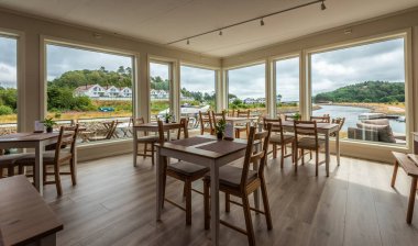 Lindesnes, Norway - July 21 2019: A cabin cruiser passing through the canal viewed from inside of Le Bistro cafe.