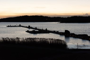 Geceleyin rıhtımdaki insanlar.