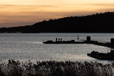 Geceleyin rıhtımdaki insanlar.