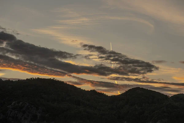日落时飞机在云彩之上的凝结线 — 图库照片