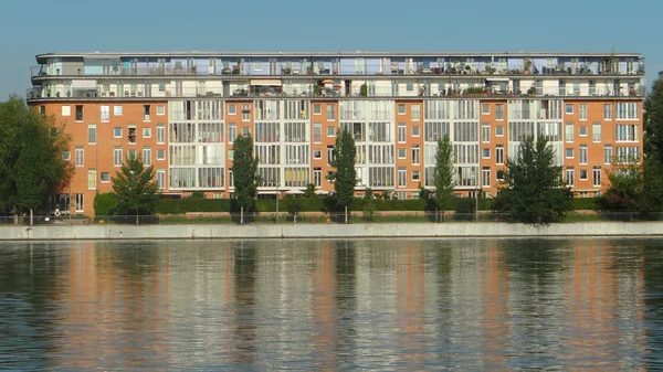 Multi-piętrowy budynek nad brzegiem rzeki — Zdjęcie stockowe
