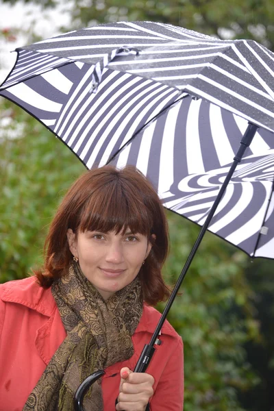 一个女人在雨中伞下 — 图库照片