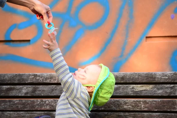 Toddler reaching for a pacifier — Stock Photo, Image