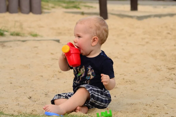 Хлопчик у пісочниці з іграшкою — стокове фото