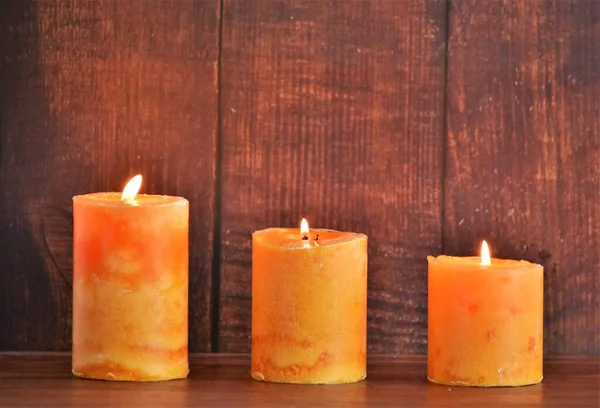 Drie Wassen Oranje Kaarsen Houten Ondergrond — Stockfoto