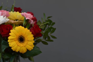 bouquet of fresh flowers in a glass decanter on a gray background 