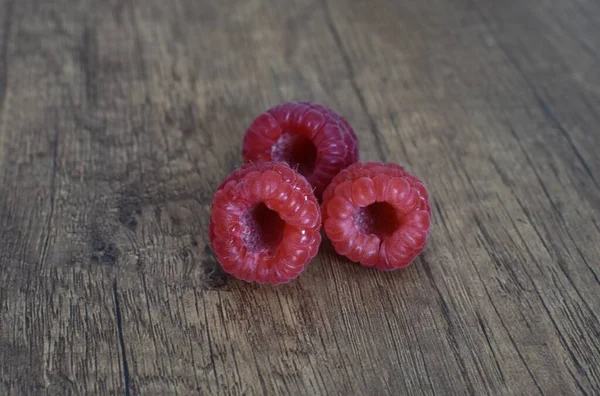 Three Ripe Raspberries Wooden Brown Table — стоковое фото