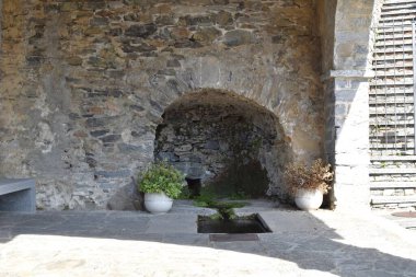 Taştan bir gölgeliğin altındaki doğal su kaynağı.